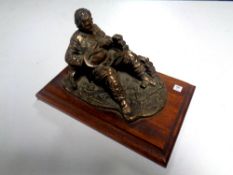 A brass figure of a fireman on wooden base