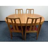 A teak veneered oval extending dining table together with a set of six rail back dining chairs