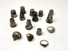 A collection of eleven white metal / silver thimbles together with four dress rings.