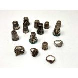 A collection of eleven white metal / silver thimbles together with four dress rings.