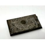 An Indian silver card case, of rectangular form, with embossed foliate and engine-turned decoration,