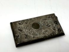 An Indian silver card case, of rectangular form, with embossed foliate and engine-turned decoration,