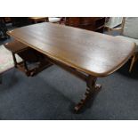 An Ercol elm dining table with under stretcher