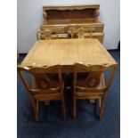 A 1930s heavily carved oak buffet sideboard together with matching pull out dining table and set of