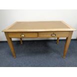 An Edwardian oak writing table fitted two drawers
