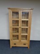 A contemporary glazed oak bookcase fitted a drawer beneath