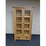 A contemporary glazed oak bookcase fitted a drawer beneath