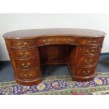 A Chapman's reproduction mahogany kidney shaped writing desk fitted nine drawers