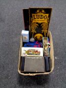 A box containing two folding vintage board games, Ludo and Snakes & Ladders,