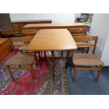 A 20th century teak drop leaf dining table and a set of four matching chairs