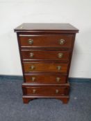 A miniature chest of five drawers