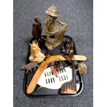 A tray containing wooden items including boomerang, African shield,