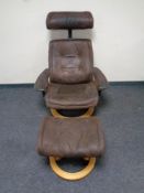 A relaxer armchair with matching footstool in brown suede upholstery on pine effect base