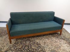 A continental beech framed settee in button green upholstery