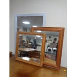Two pine framed mirrors together with a further silvered framed mirror