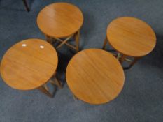 A set of four teak folding stools