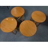 A set of four teak folding stools