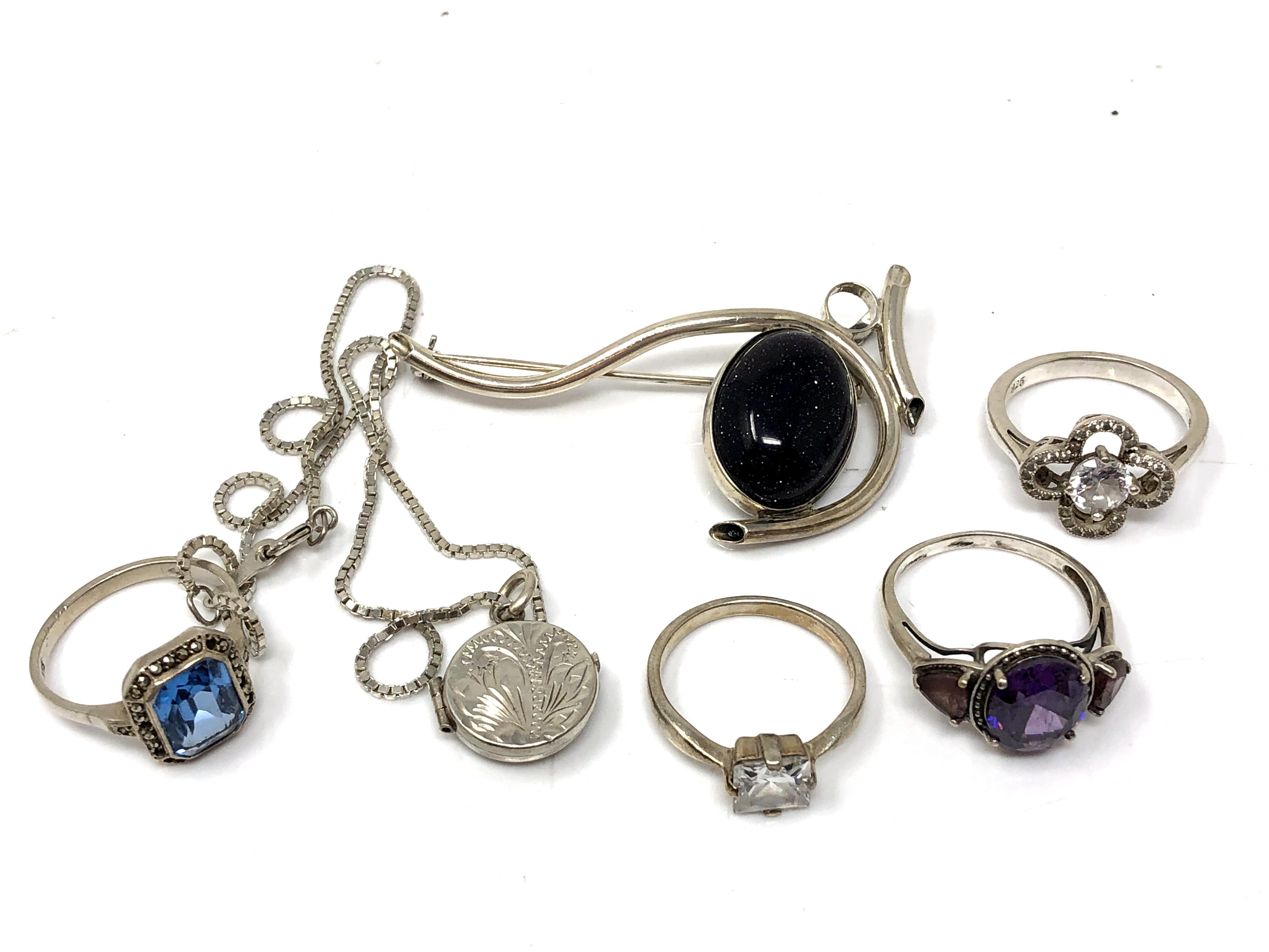 A silver brooch together with dress rings,