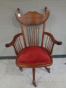 A spindle back armchair on castors