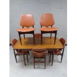 A 20th century teak pull out extending dining table together with a set of six matching armchairs