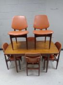 A 20th century teak pull out extending dining table together with a set of six matching armchairs