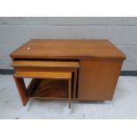 A teak turnover top coffee table fitted two nesting tables