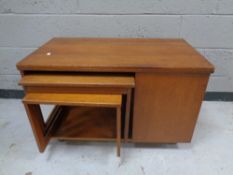 A teak turnover top coffee table fitted two nesting tables