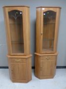 A pair of contemporary glazed door corner cupboards,