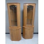 A pair of contemporary glazed door corner cupboards,