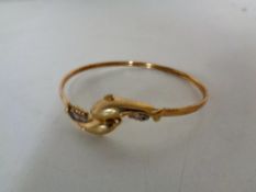 A 9ct gold dolphin bangle set with diamonds CONDITION REPORT: 7.