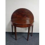 A George III mahogany turnover top D-shaped table