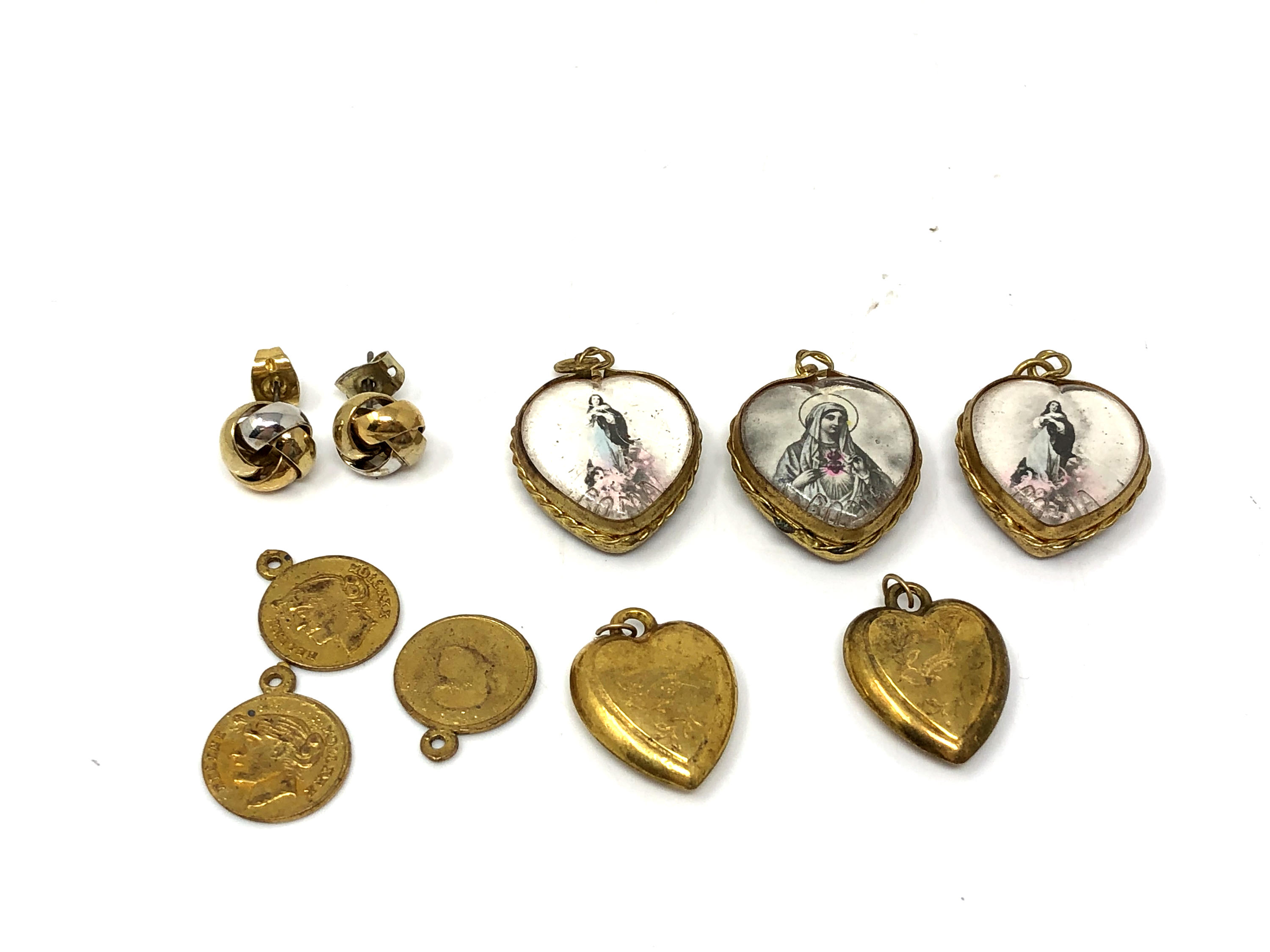 A small collection of heart shaped lockets, religious pendants,