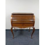 A continental walnut cylinder bureau on cabriole legs