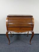 A continental walnut cylinder bureau on cabriole legs