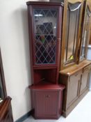 A corner display cabinet in a mahogany finish