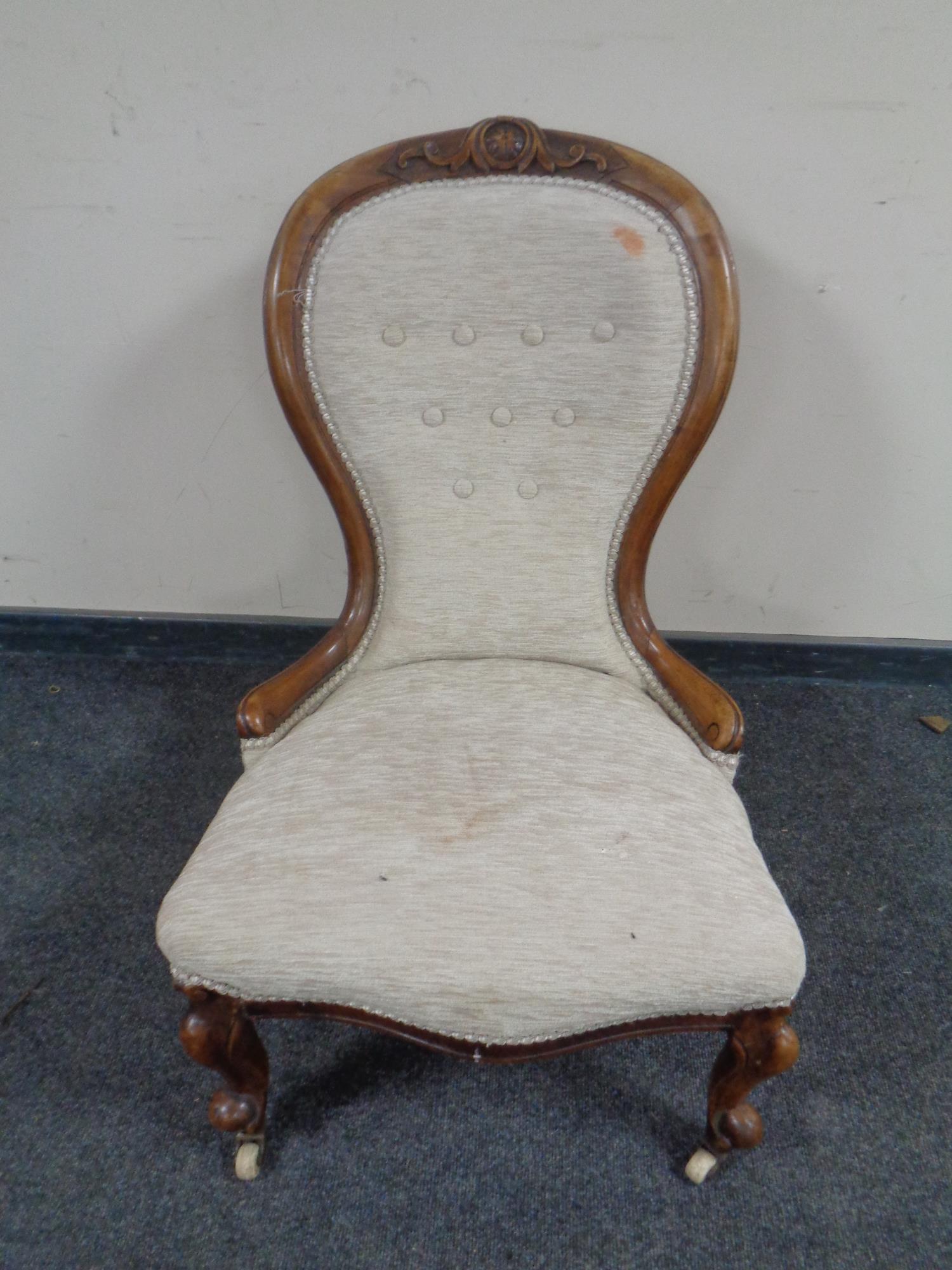 A Victorian carved walnut lady's chair in button upholstery