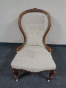 A Victorian carved walnut lady's chair in button upholstery