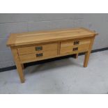 A contemporary oak four drawer side table