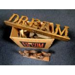 A box containing wooden items including decorative signs, wooden bust,