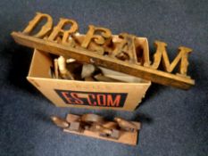 A box containing wooden items including decorative signs, wooden bust,