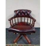 A Chesterfield style swivel desk chair in burgundy leather upholstery