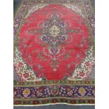 A Persian Kirman carpet on red and green ground,