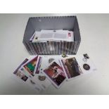 A box containing approximately 30 Royal Commemorative Coin First Day covers