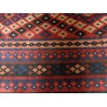A flat weave kilim on red ground,