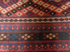 A flat weave kilim on red ground,