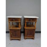 A pair of continental mahogany marble topped bedside stands