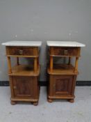 A pair of continental mahogany marble topped bedside stands