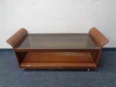 A mid 20th century G-Plan teak two tier coffee table on castors with smoked glass inset.