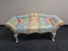 A window seat in buttoned fabric on painted legs