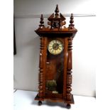 An Edwardian Vienna style wall clock with brass and painted dial, pendulum and key.